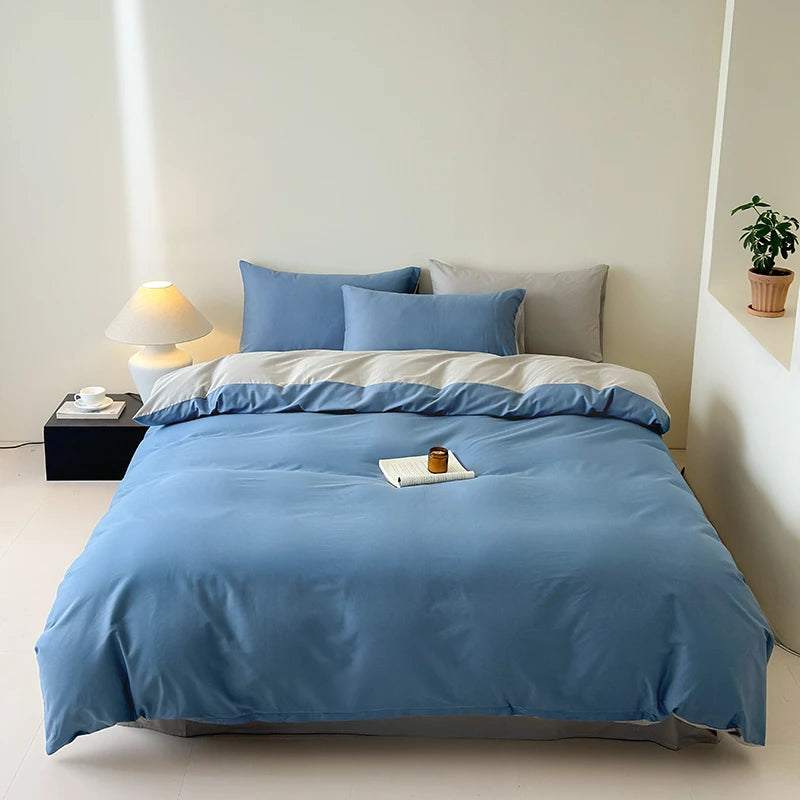 Bed and gray with blue bedding in a minimalistic room