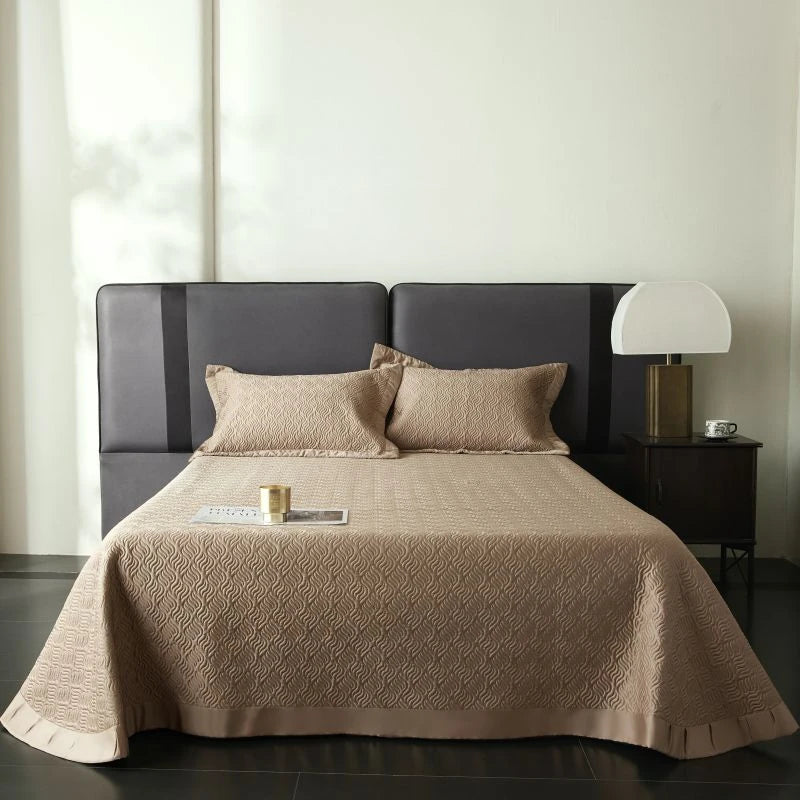 Bed with brown quilt and pillows in a room.