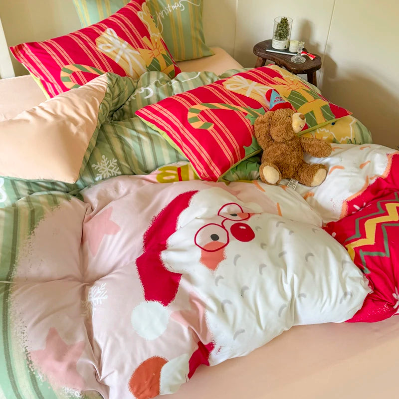 Bed with colorful bedding featuring a Santa Claus design, surrounded by pillows and a teddy bear.