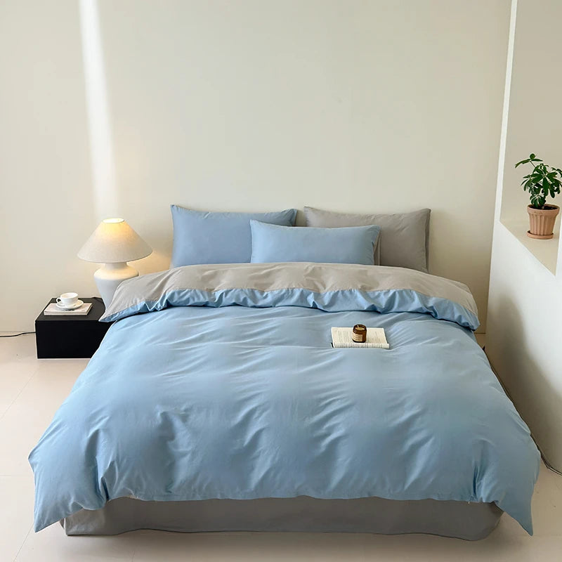 Bed with light blue bedding in a minimalistic room.