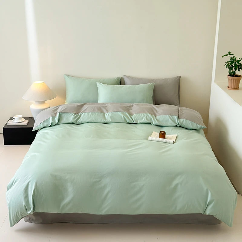 Bed with mint green and gray bedding in a minimalistic bedroom setting.