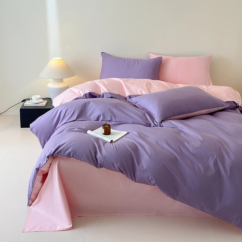 Bed with pink and purple bedding in a minimalistic room.