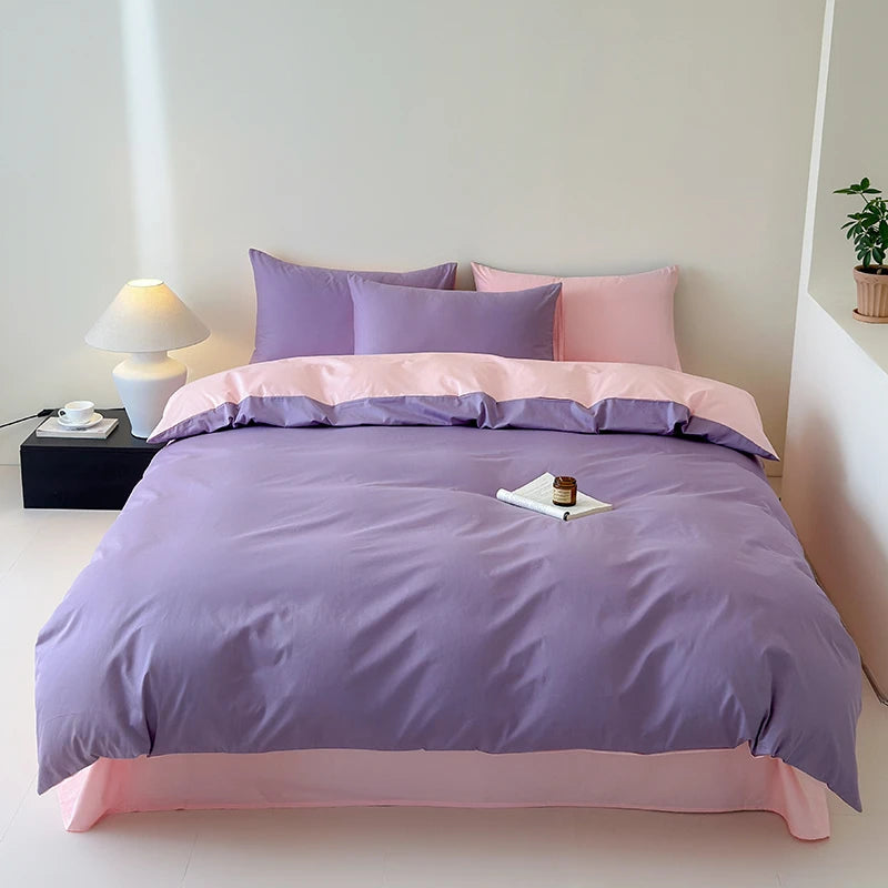 Bed with purple and pink bedding in a minimalistic room.