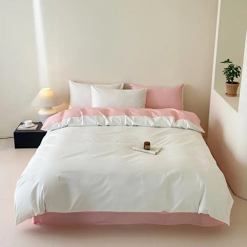Bed with white and pink bedding in a minimalistic room.