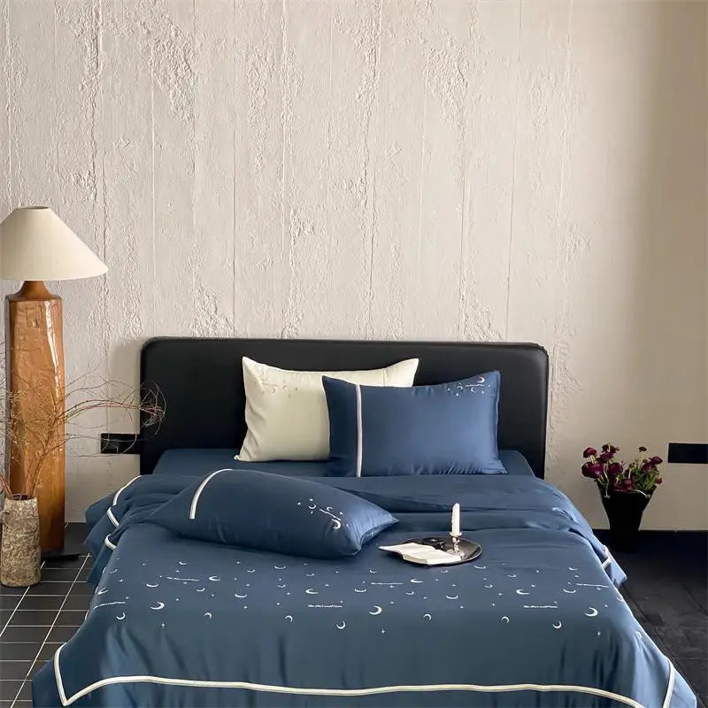 Bedroom with blue bedding and decorative pillows against a textured wall.
