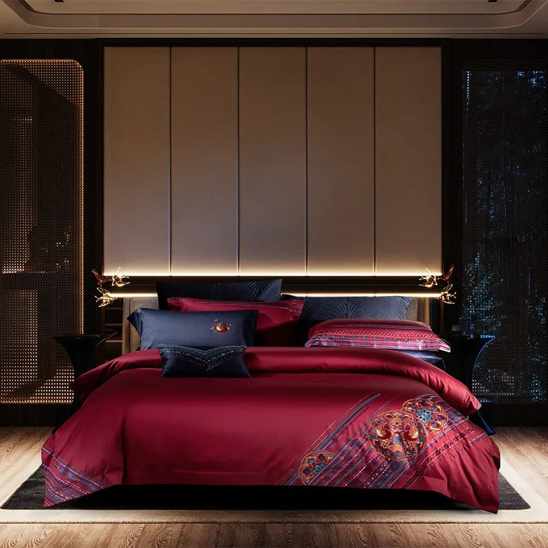Bedroom with red bedding and decorative pillows against a dark wall.