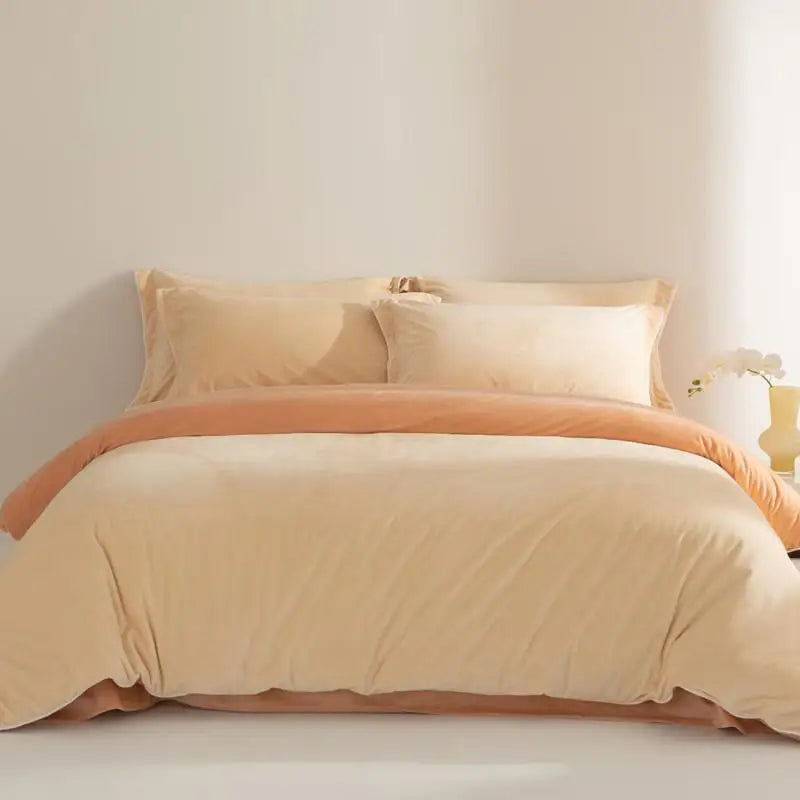 Beige and orange bedspread set on a bed with a neutral background