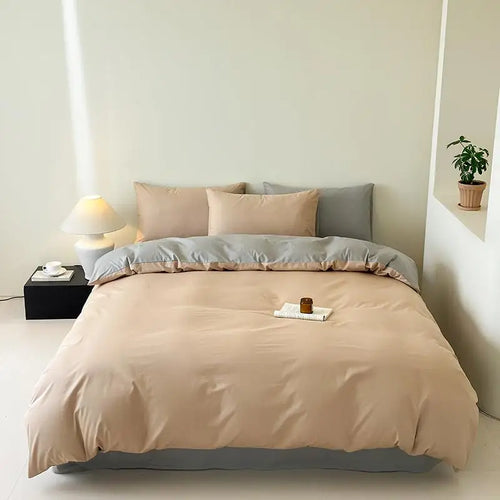 Beige bedding set on a bed in a minimalistic room with a lamp and plant.