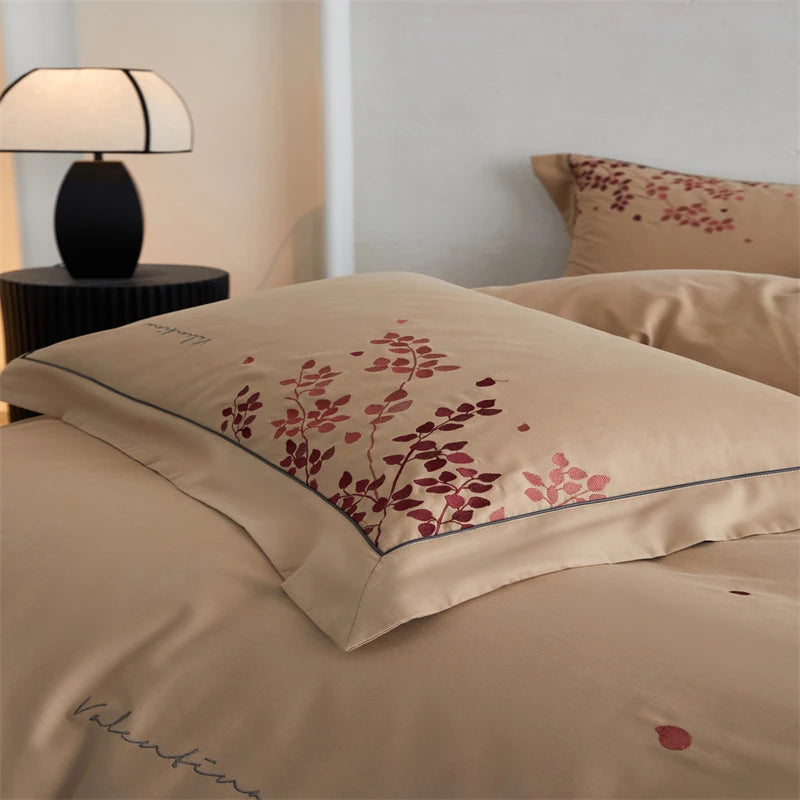 Beige bedding set with floral patterns on a bed in a bedroom setting.