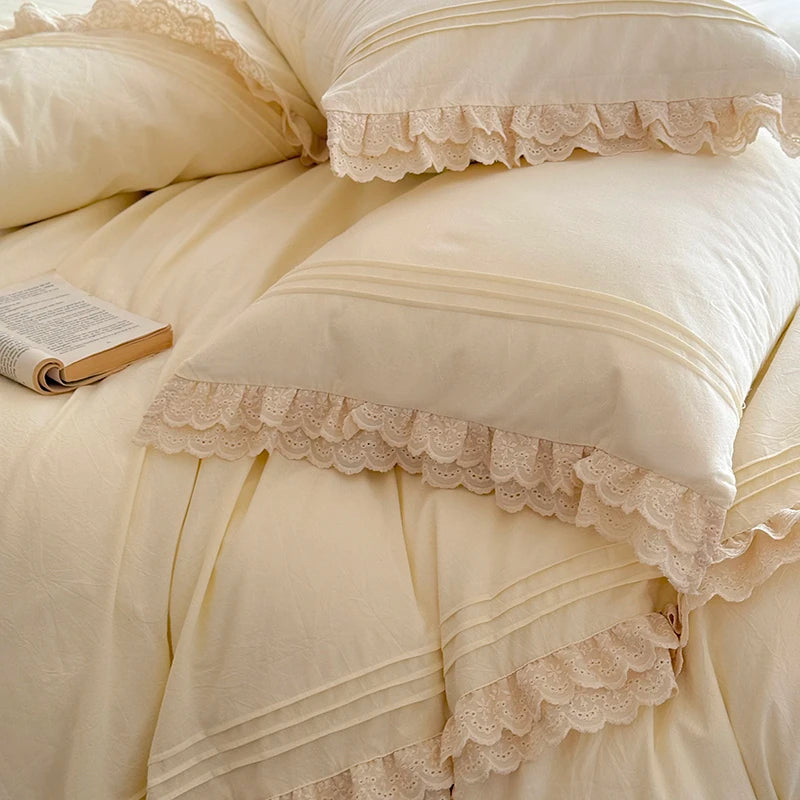 Beige bedding set with lace details and a book on a bed.