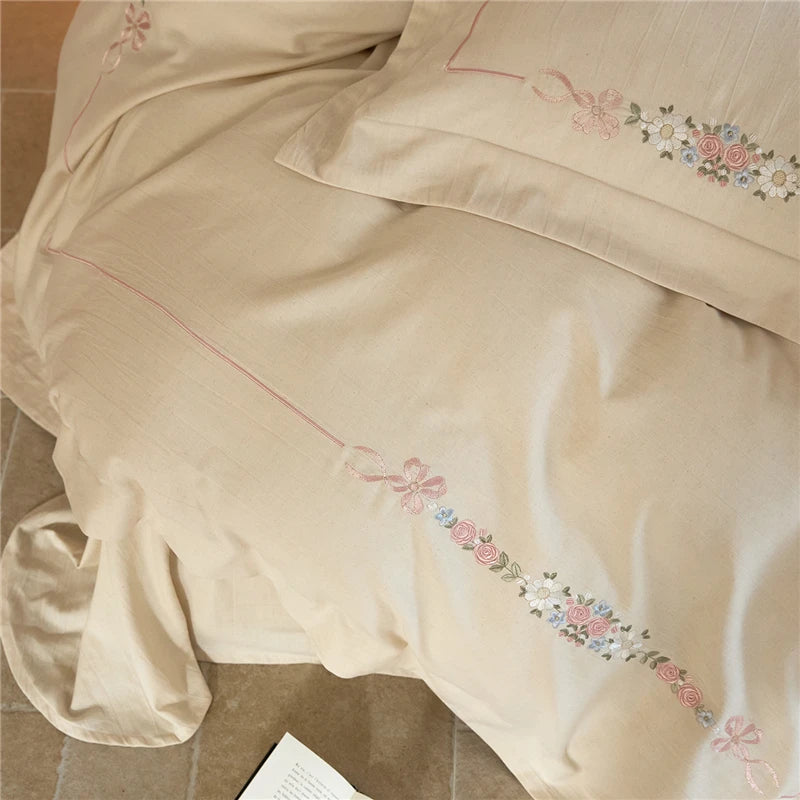 Beige duvet cover with floral embroidery on a wooden surface