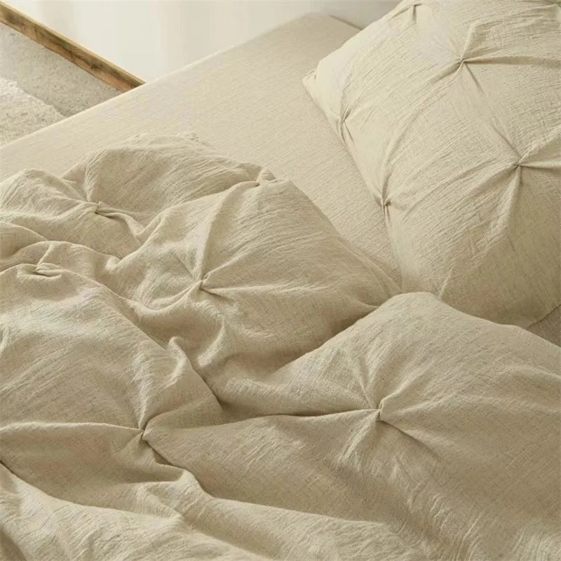 Beige pleated duvet cover on a bed with pillows