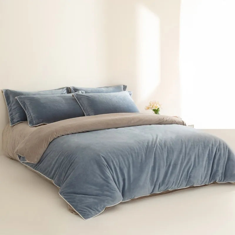 Blue and gray bedding set on a bed in a bright room