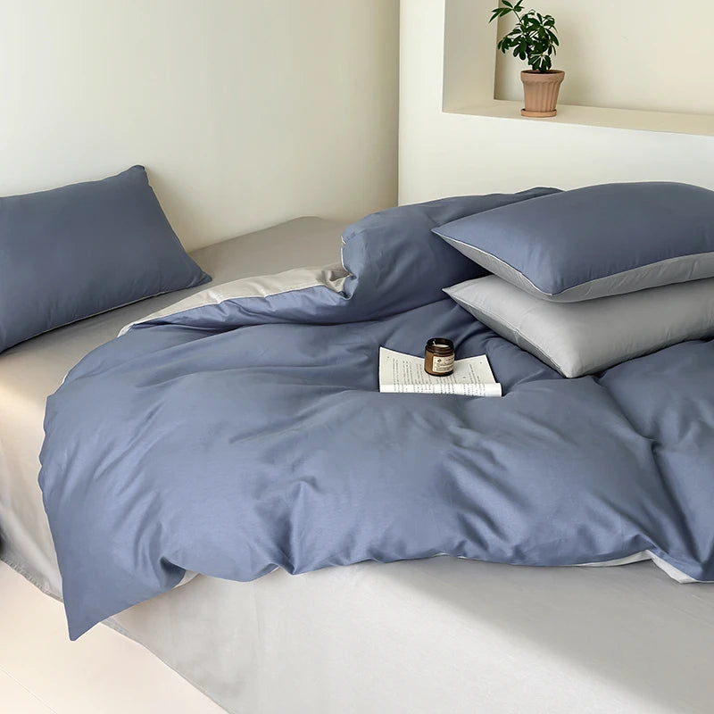 Blue bedding set on a bed with a small plant in the background
