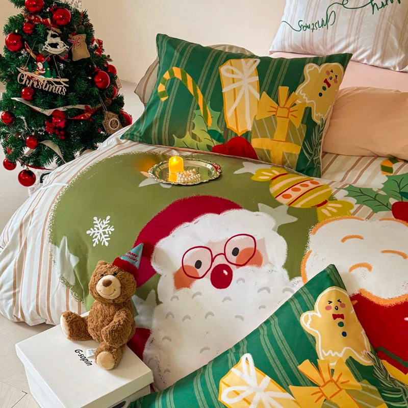 Christmas-themed bedding set with Santa Claus and gingerbread design, accompanied by a small teddy bear and decorated Christmas tree.