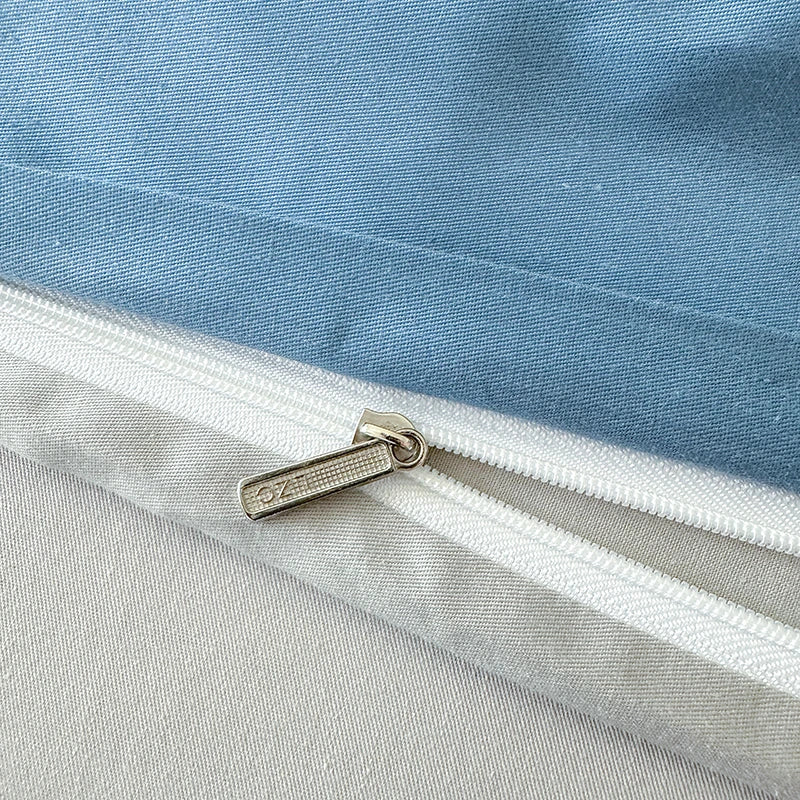 Close-up of a zipper on a blue and gray fabric background with a brand logo.