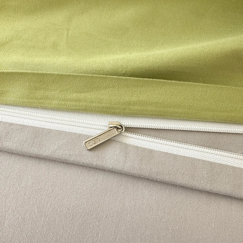 Close-up of a zipper on a fabric featuring green and beige colors.