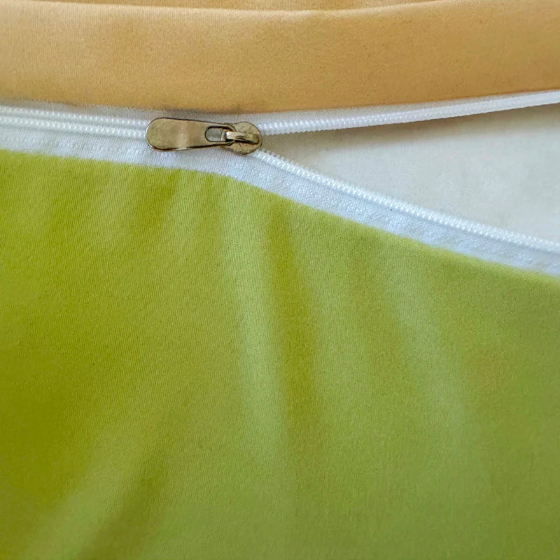 Close-up of a zipper on a green fabric with a top.