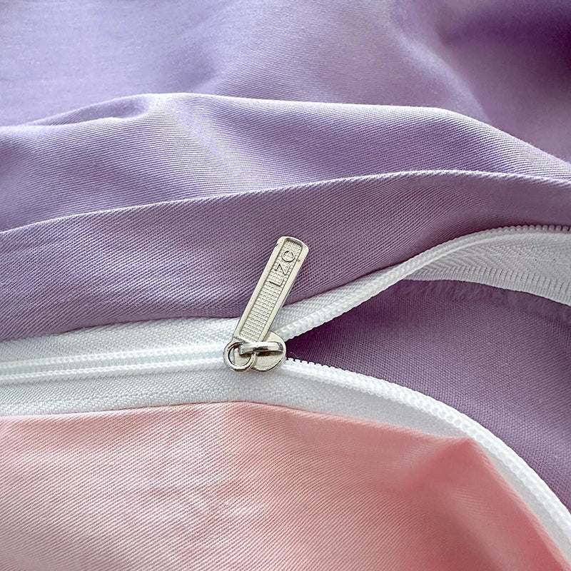 Close-up of a zipper on a piece of fabric with a gradient from purple to pink.