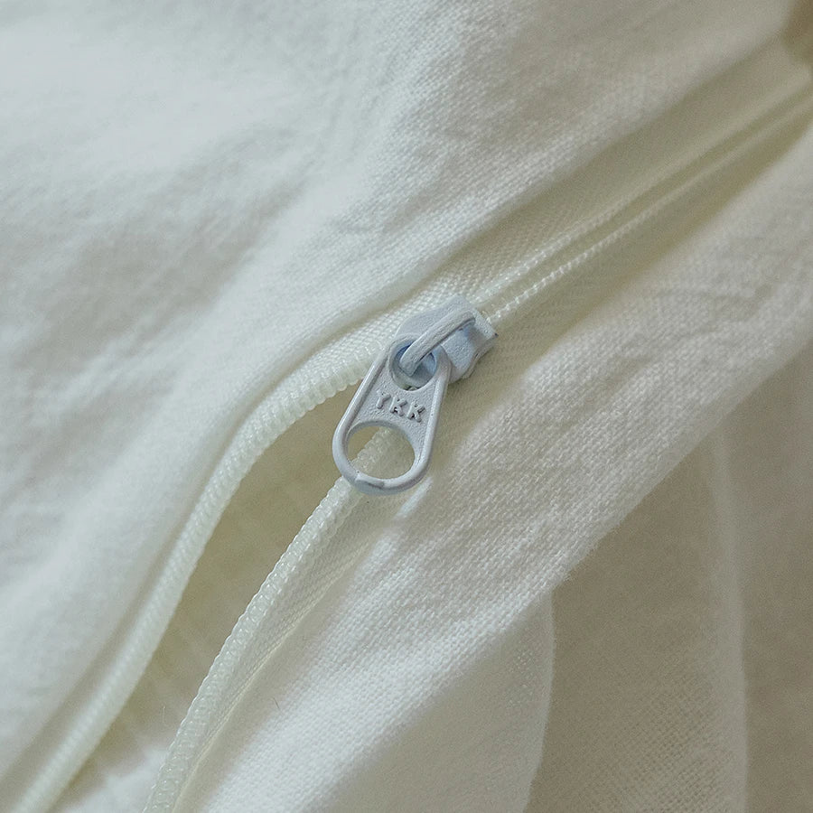 Close-up of a zipper on a white bedding set duvet cover fabric 