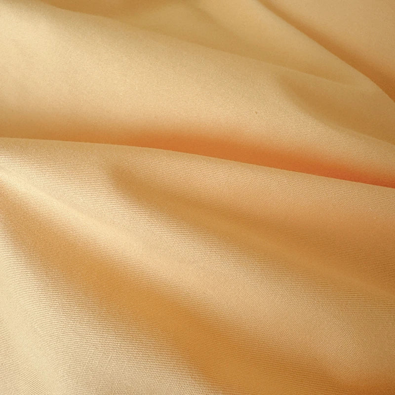 Close-up of mango color fabric with folds