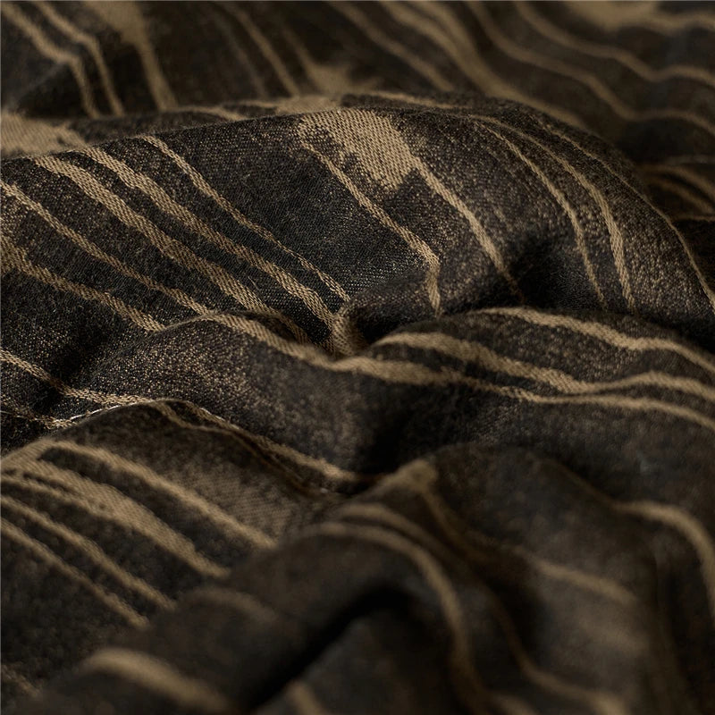 Close up of a beige and brown stripe quilted blanket