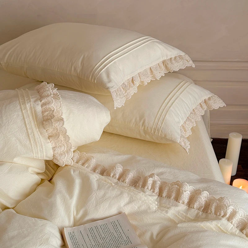 Cream-colored bedding with lace trim on a bed