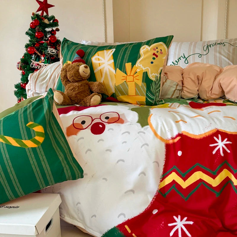 Decorative pillows and blanket with Christmas-themed bedding set on a bed.