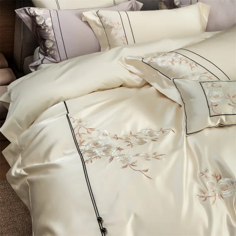 Embroidered bedding set with floral patterns on a bed.