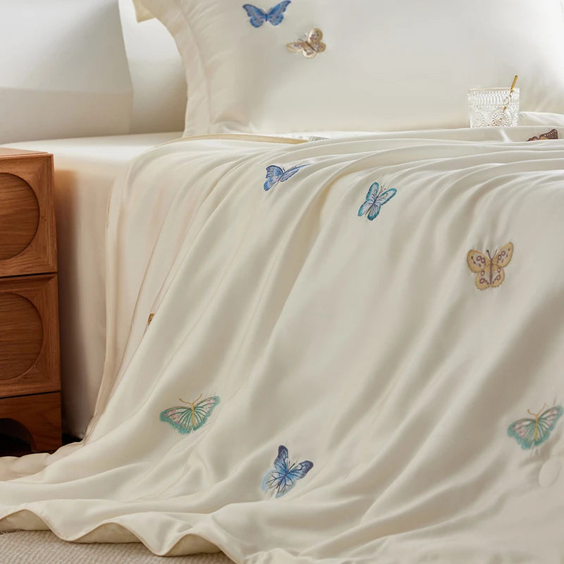 Embroidered butterflies on a bed in a bedroom setting.