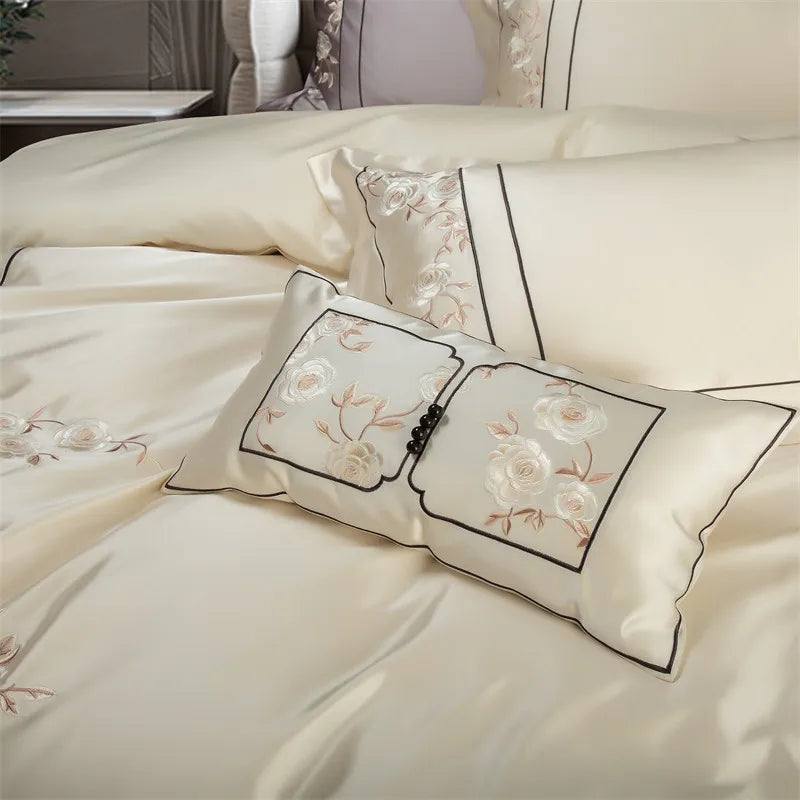 Embroidered pillows on a bed with floral designs