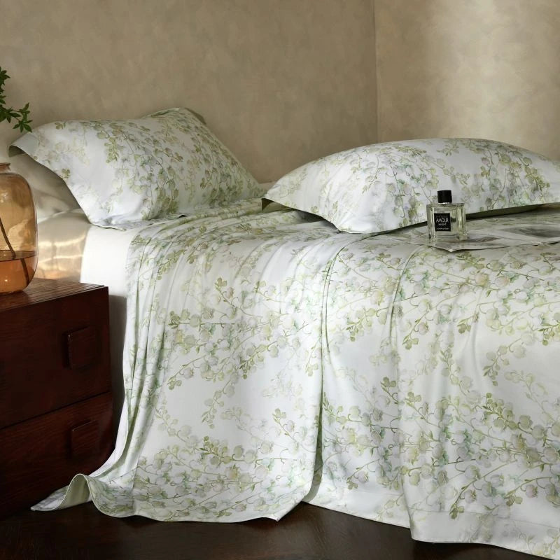 Floral bedding set on a bed with a wooden nightstand.
