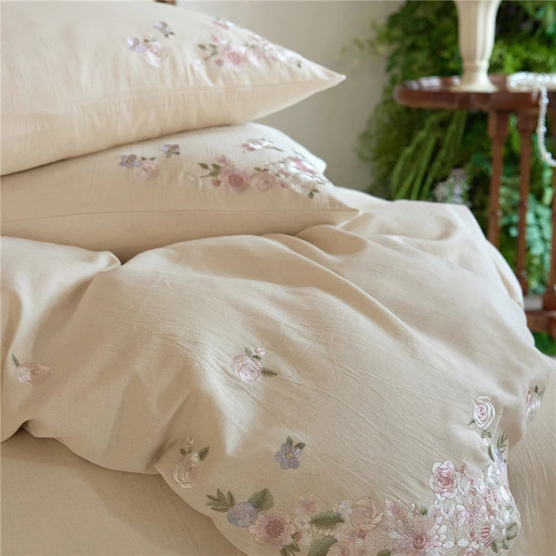Floral embroidered bedding set on a bed with a blurred background