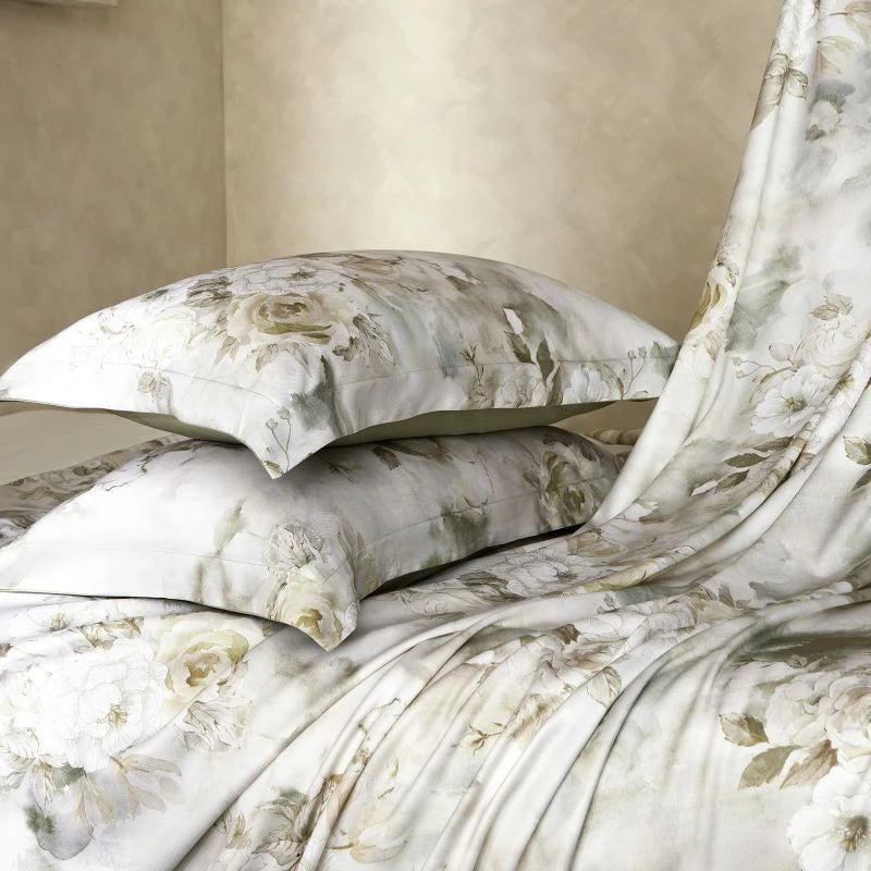 Floral patterned bedding set on a bed with beige walls.