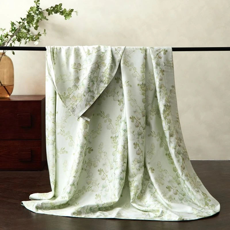 Floral patterned bedsheet with a wooden cabinet and plant in the background