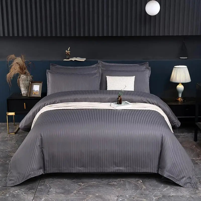 Gray bedding set on a bed in a bedroom with dark walls and decor.