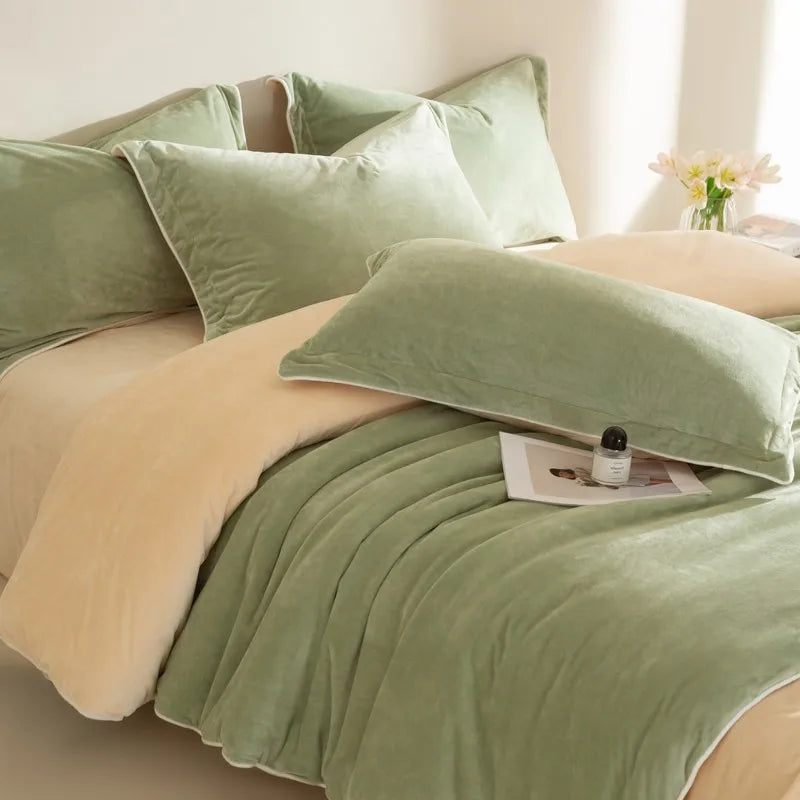 Green and beige reversible bedding set with pillows on a bed.