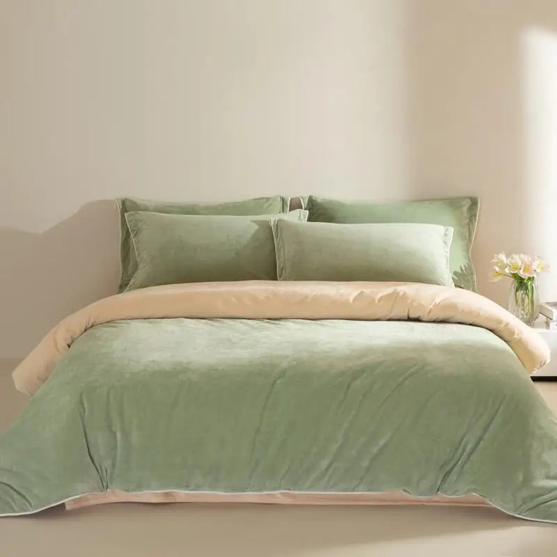 Green bedding set with olive trim on a bed against a neutral wall.