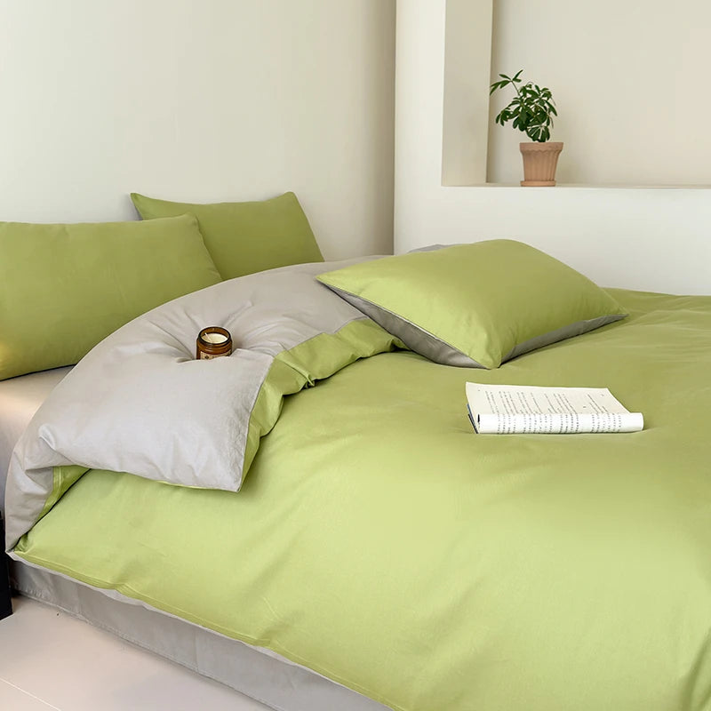 Green bedding set with pillows and a book on a bed in a room.