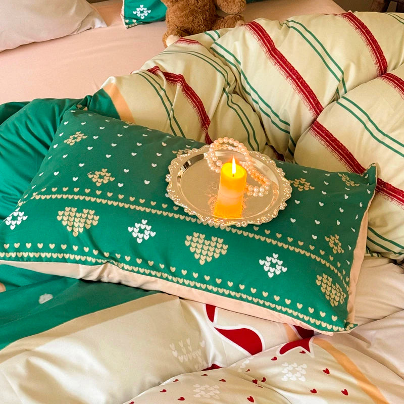 Green pillow with heart pattern on a bed with red and white striped pillows and a candle.