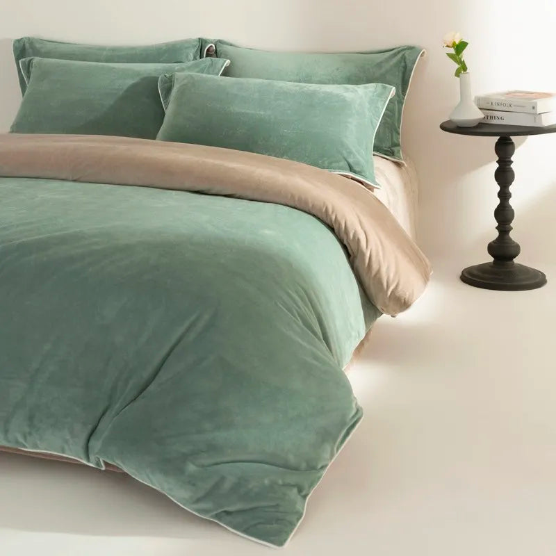 Green velvet bedding set on a bed with a side table in the background