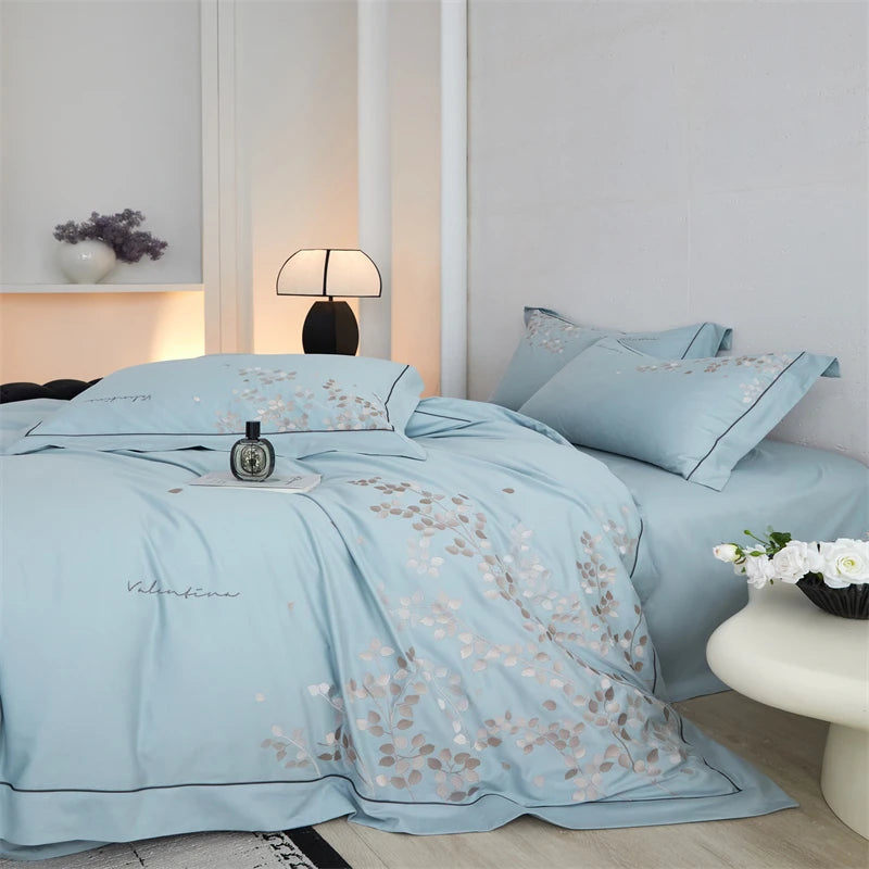 Light blue floral bedding set on a bed in a bedroom setting.