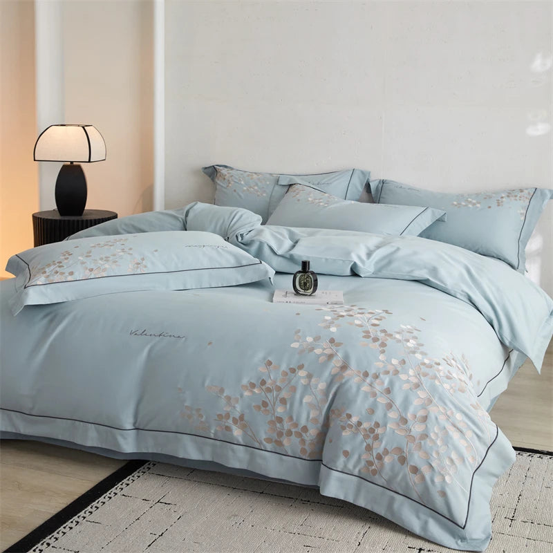 Light blue floral patterned bedding set on a bed in a bedroom.