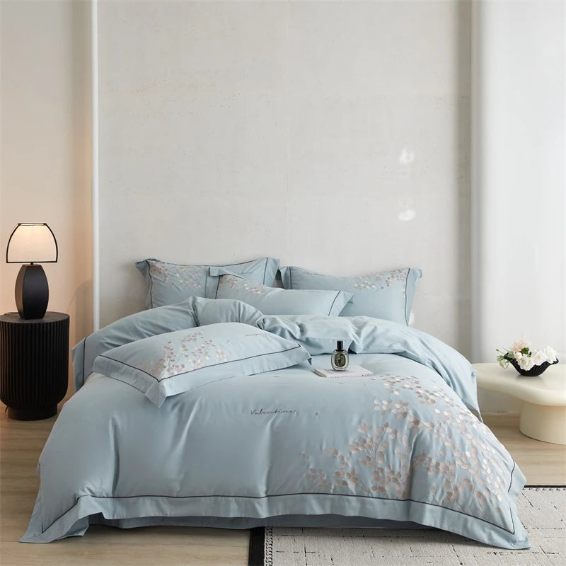 Light blue floral patterned bedding set on a bed in a bedroom setting.