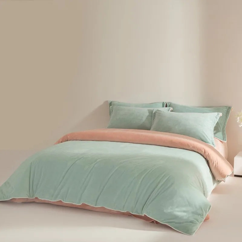 Light green bedding set with peach trim on a bed against a beige wall.