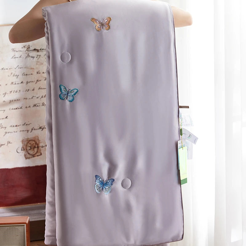 Light purple bedding set with butterfly embroidery on a white background