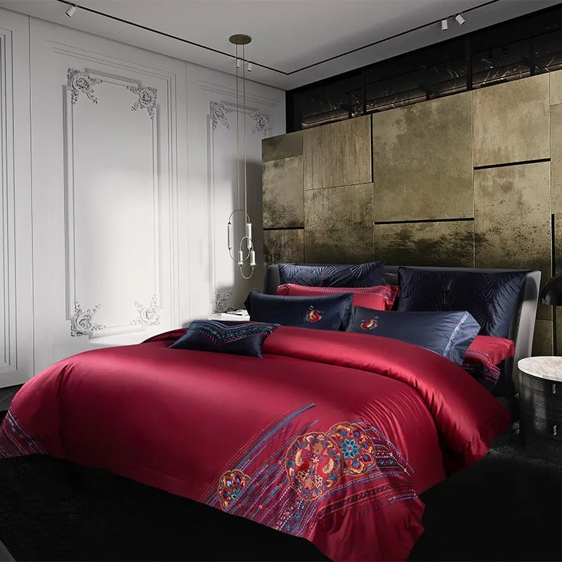 Luxurious bedroom with red bedding and decorative pillows in a modern room.