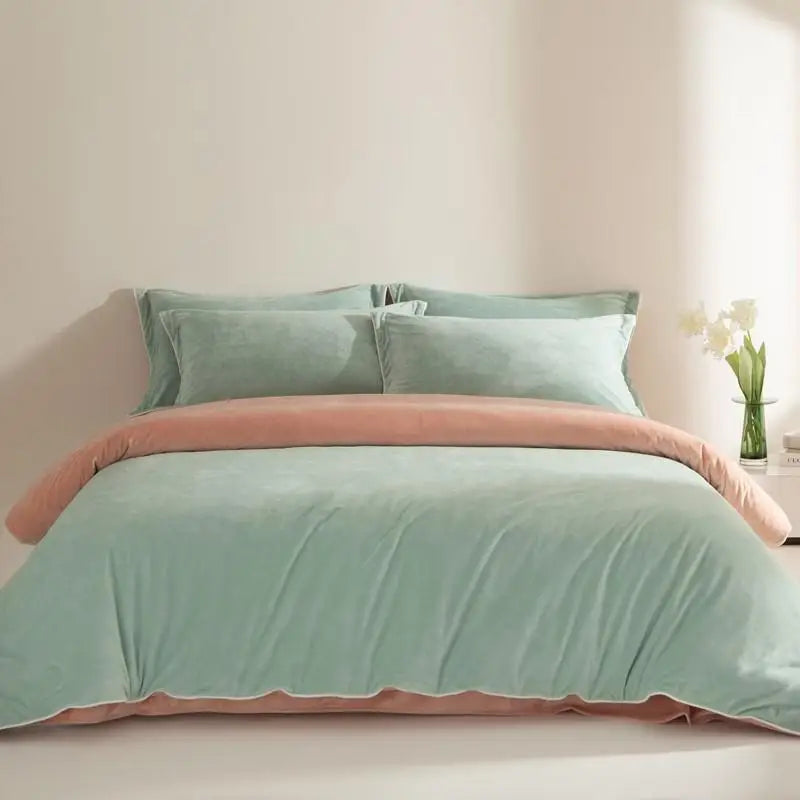 Mint green duvet cover set with peach trim on a bed in a bedroom.
