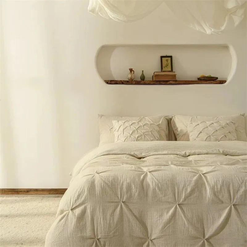 Neatly made bed with Pleated pillowcases in a room with a shelf on the wall.