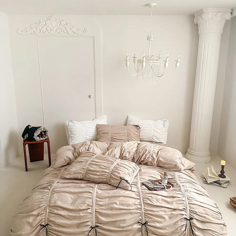 Neatly made bed with beige bedding in a well-lit bedroom.